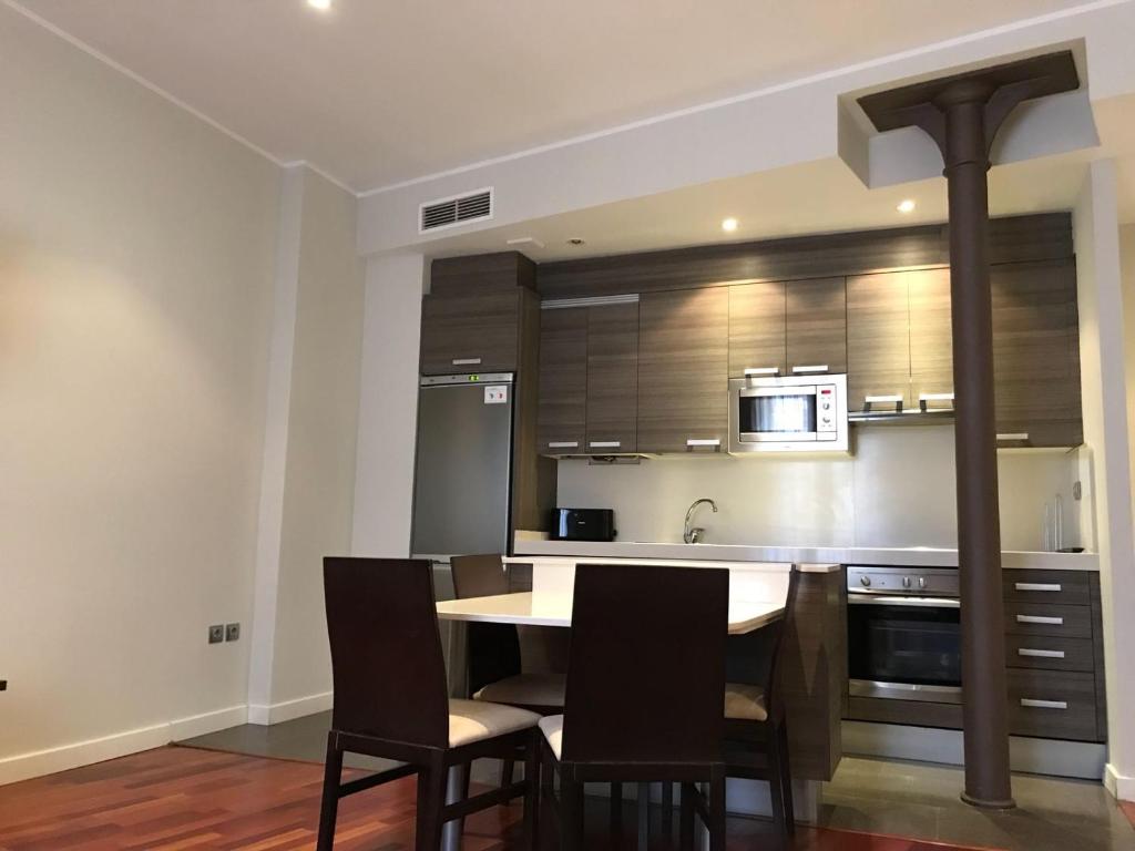 a kitchen with a table and chairs and a microwave at AZ El Balcón de Rey Alfonso II in Zaragoza