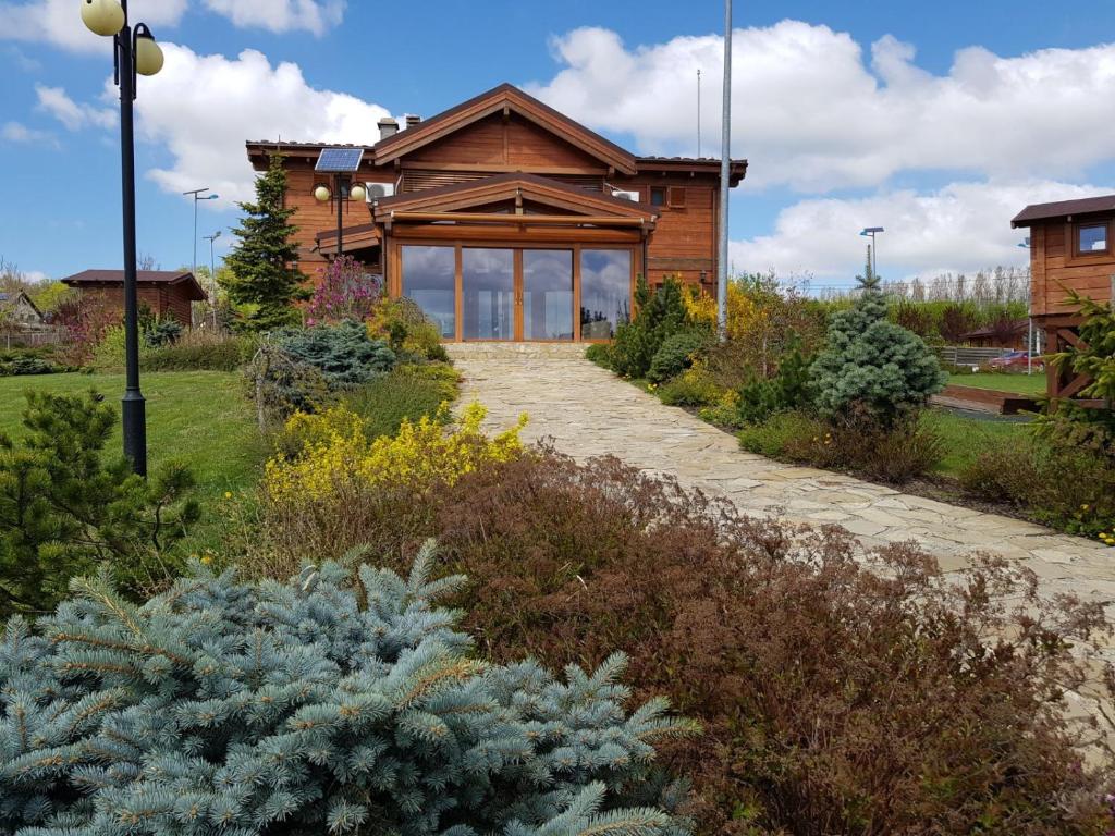 a wooden house with a pathway in front of it at Sat de vacanta Ciprian Porumbescu in Suceava