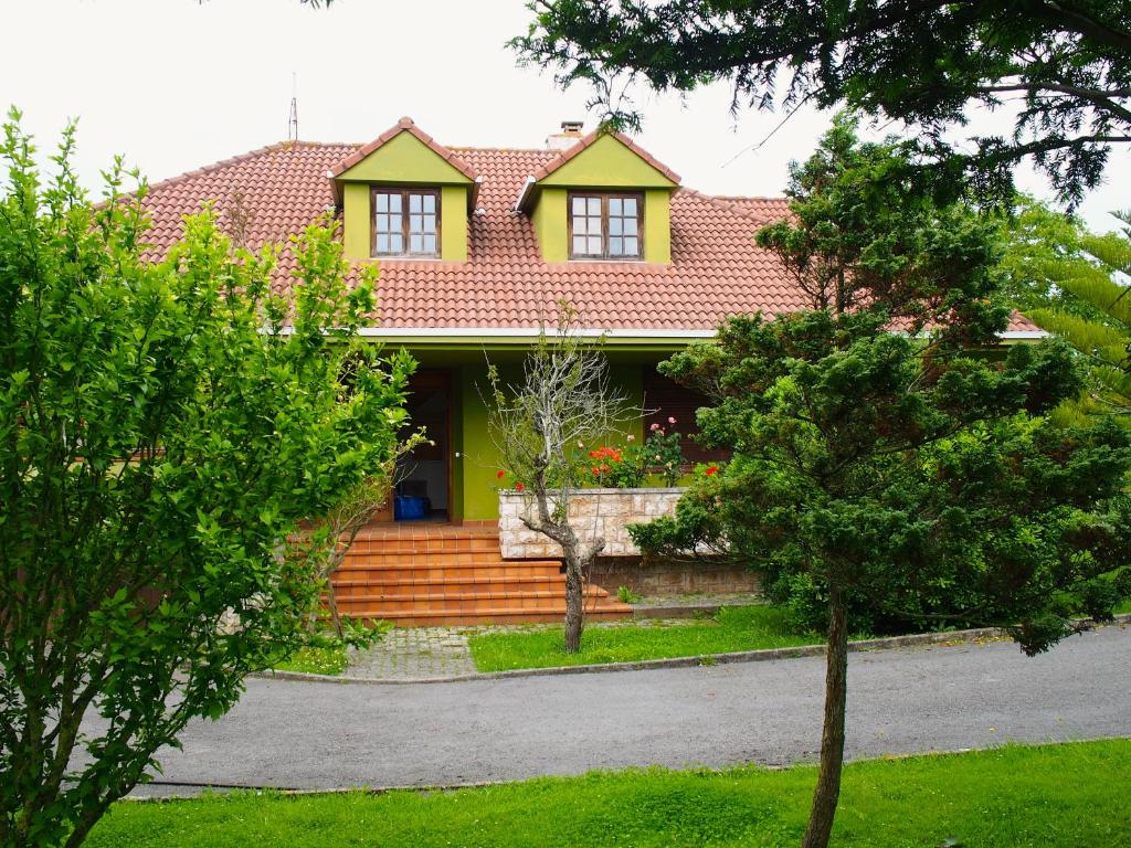 オレニャにあるCasa Cameliaの赤屋根の黄色い家