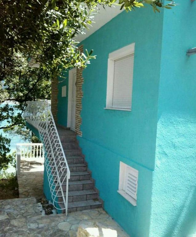 a blue building with stairs leading up to a door at Apartman Volarevic in Donji Karin