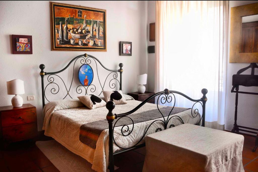 a bedroom with a bed and a painting on the wall at Relais del Porto in Cagliari