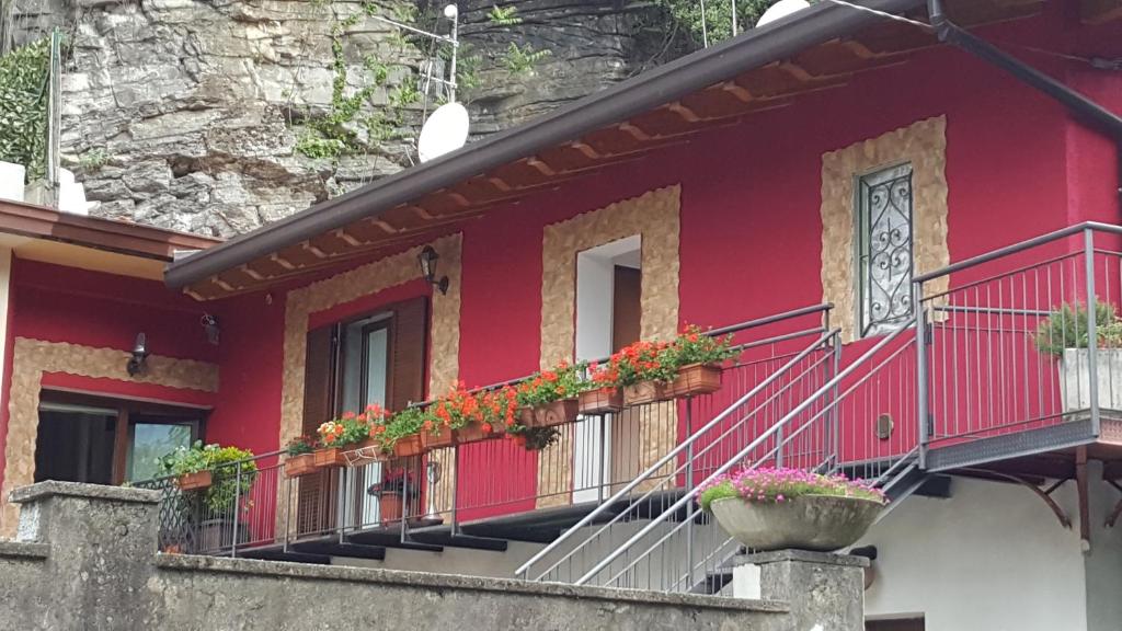 ein rotes Gebäude mit Topfpflanzen auf den Balkonen in der Unterkunft Apartment Regina Uno in Como