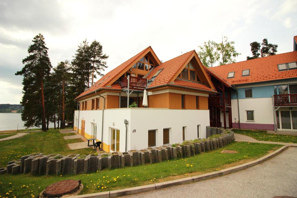 una grande casa con una recinzione di fronte di Apartment Riviera 503-8 Lipno Home a Lipno nad Vltavou