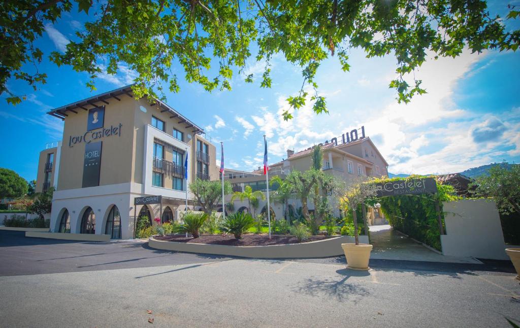 a large building with trees in front of it at Hotel Lou Castelet in Carros