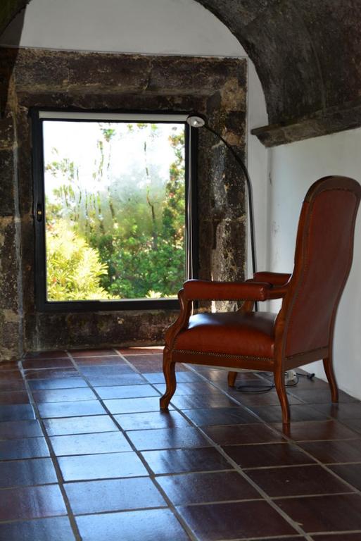 a chair sitting in a room with a window at Convento de São Francisco in Vila Franca do Campo