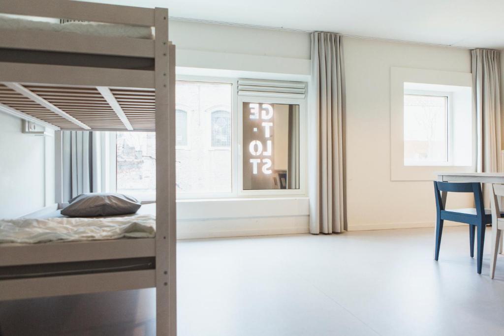 - une chambre avec des lits superposés et une table dans l'établissement Snuffel Youth Hostel, à Bruges