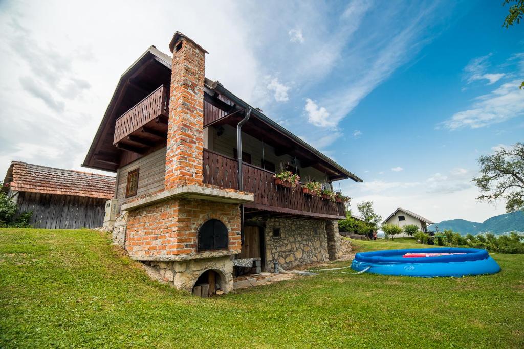 um edifício de tijolos com uma varanda e dois frisbees na relva em Sunny House with Sauna em Bistrica ob Sotli