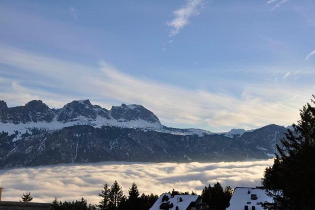 a view of a mountain range with clouds in front at Haus Alvier - CharmingStay in Flumserberg