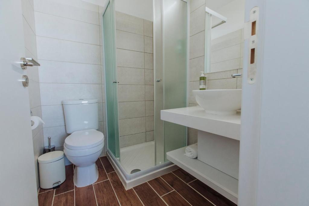 a bathroom with a toilet and a shower and a sink at River View Boutique Apts in Ayia Napa