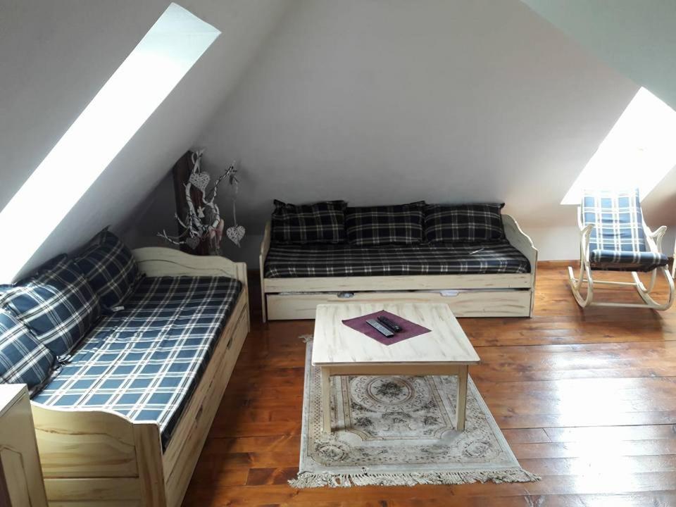a living room with two beds and a table at apartman-bartko in Banská Štiavnica