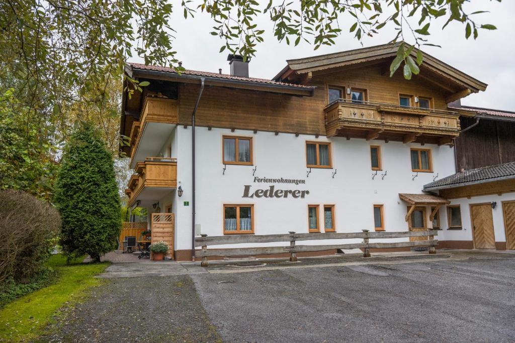 ein großes weißes Gebäude mit einem Holzdach in der Unterkunft Ferienwohnung Lederer in Söll