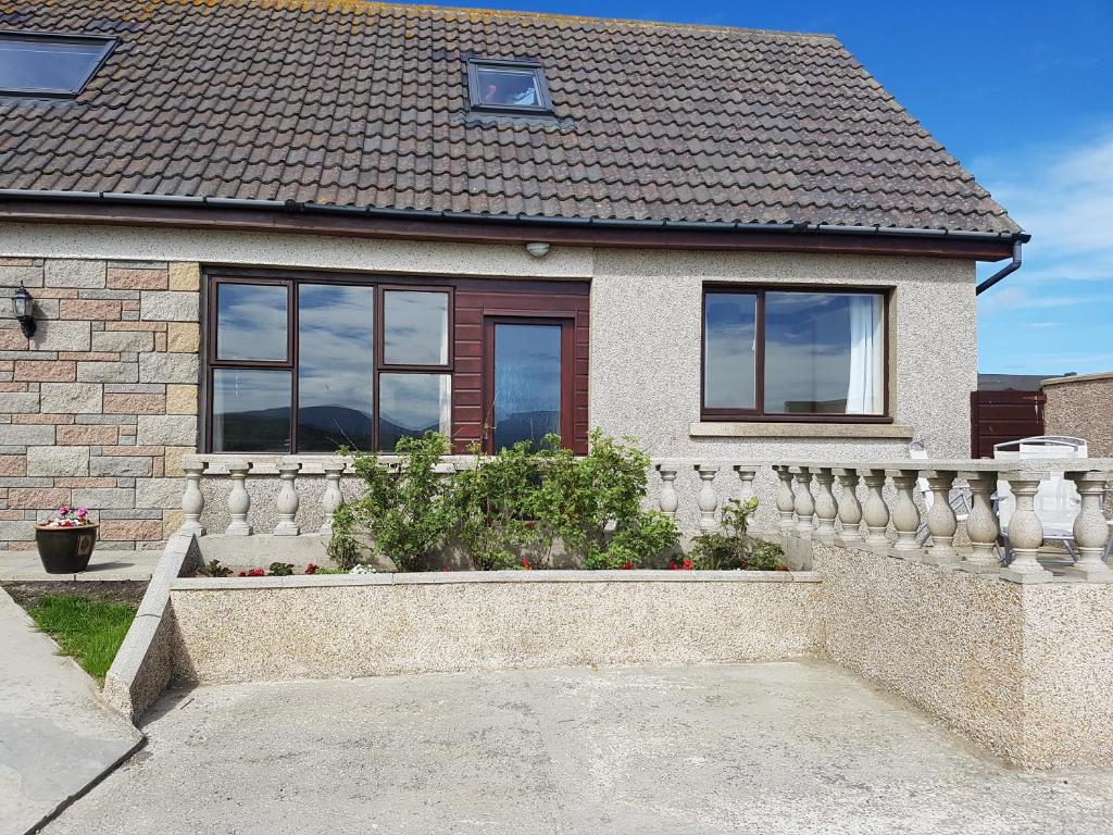 a house with a white fence in front of it at Lindisfarne Self Catering in Navershaw