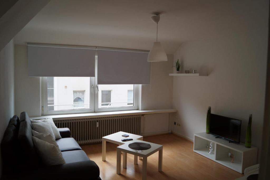 a living room with a couch and a tv at Apartment Krefeld City in Krefeld