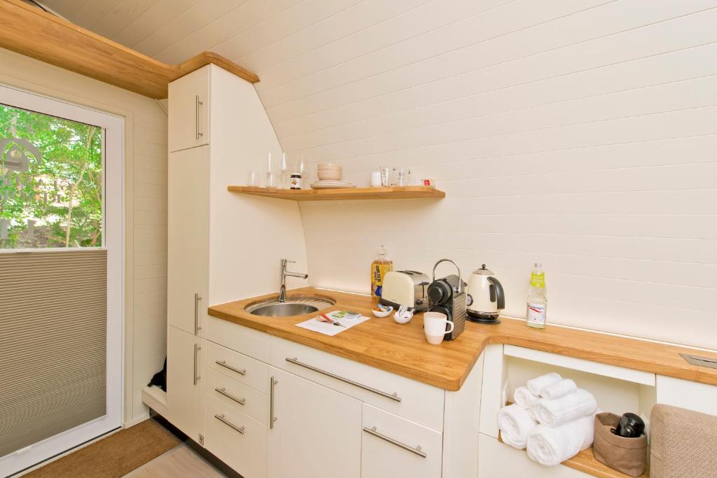 una pequeña cocina con fregadero y encimera en Glamping Resort Biosphäre Bliesgau, en Kleinblittersdorf