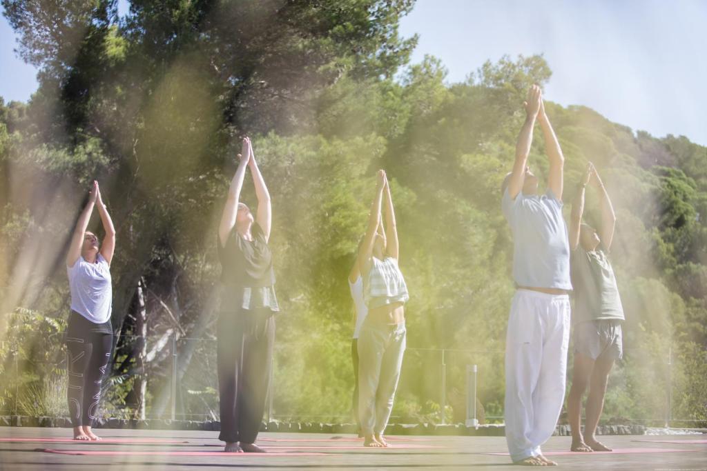 a group of people doing a yoga pose in front of a fountain at Hotel Santa Marta in Lloret de Mar