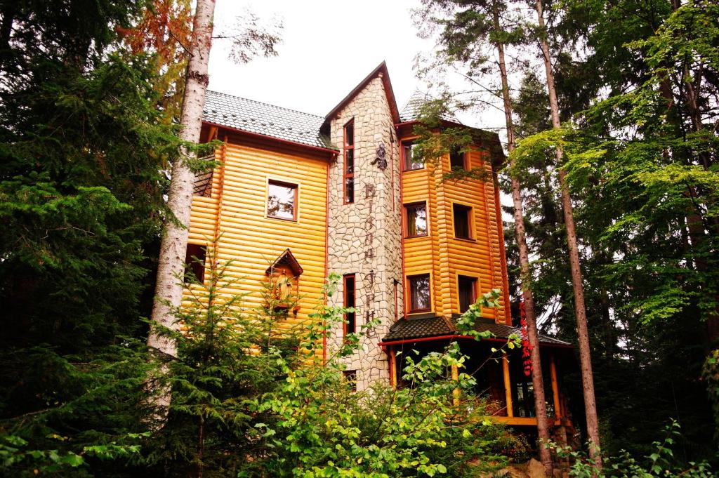 a yellow house in the middle of a forest at Villa Iris in Yaremche