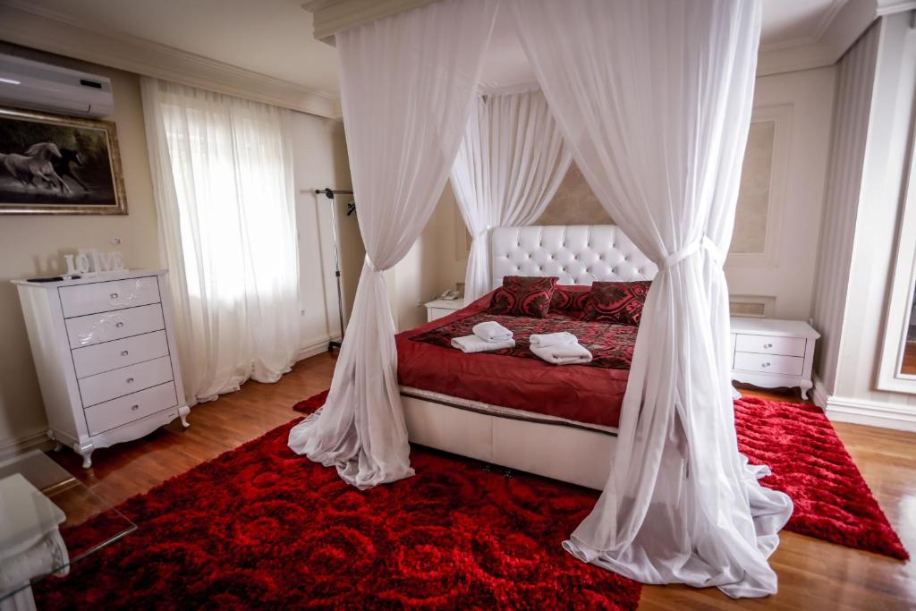 a bedroom with a canopy bed and a red rug at Hotel BOB in Sarajevo
