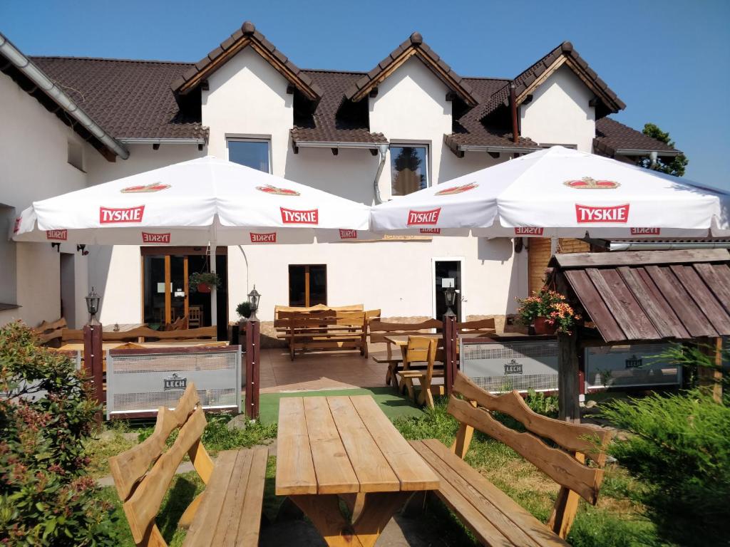 une maison avec 2 parasols sur une terrasse dans l'établissement Zajazd Park, à Łęknica