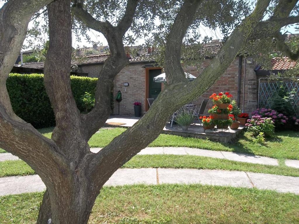 un árbol frente a una casa con flores en La Casina apartament, en Ferrara