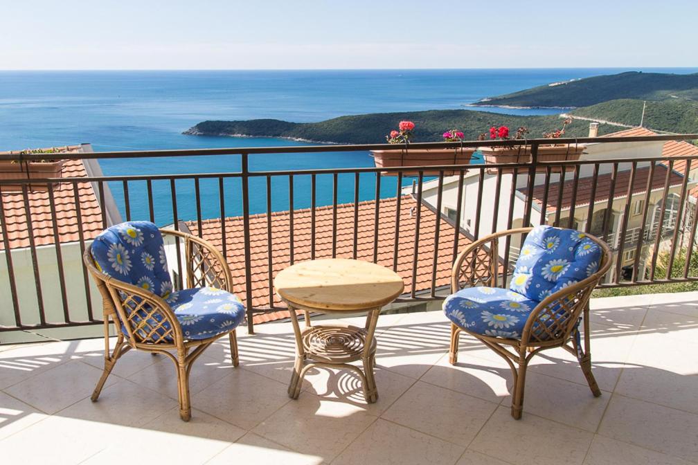 three chairs and a table on a balcony with the ocean at Villa Palma Ceoce in Budva