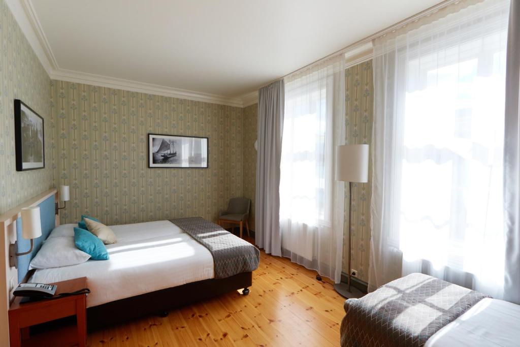 a hotel room with two beds and a window at Fosshotel Eastfjords in Fáskrúðsfjörður