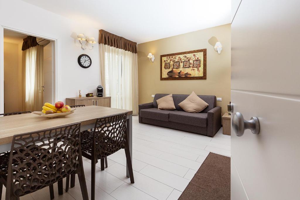 奧爾比亞的住宿－中心公寓式酒店，厨房以及带桌子和沙发的客厅。