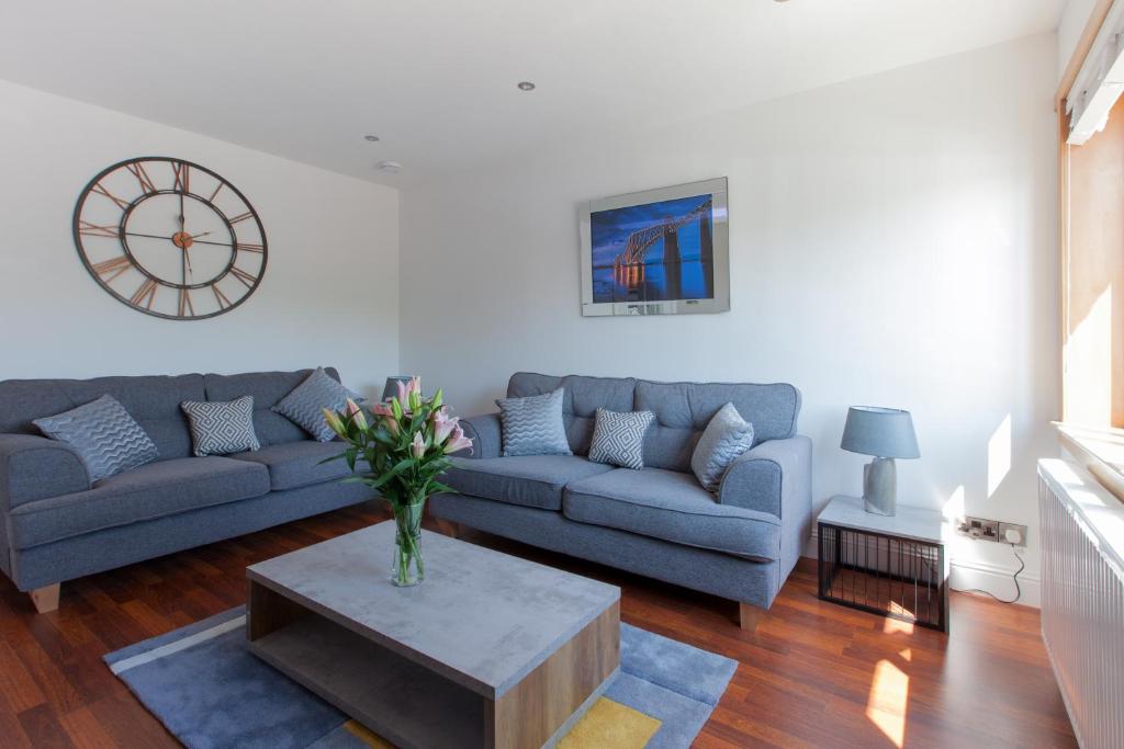 ein Wohnzimmer mit einem Sofa und einem Tisch in der Unterkunft Leys Park Executive Apartments in Dunfermline