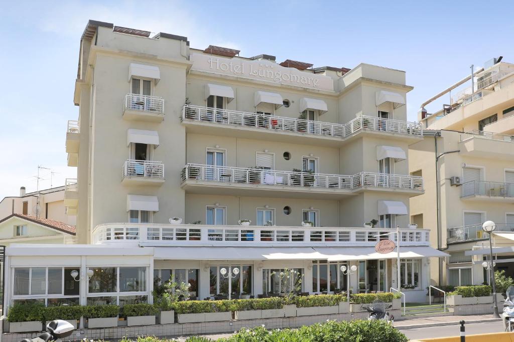 un bâtiment d'hôtel avec des balcons blancs dans une rue dans l'établissement Hotel Lungomare, à Cattolica
