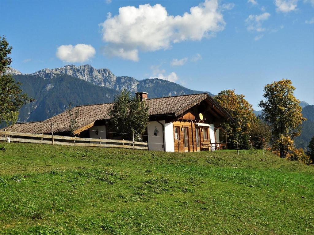 a house on a hill with mountains in the background at Eggerhof - Ferienhaus in Ramsau am Dachstein