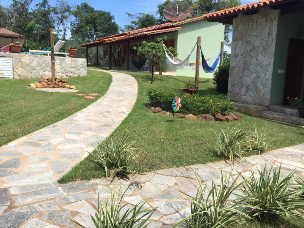 um jardim com um passadiço de pedra ao lado de uma casa em Estancia Maria em Pirenópolis
