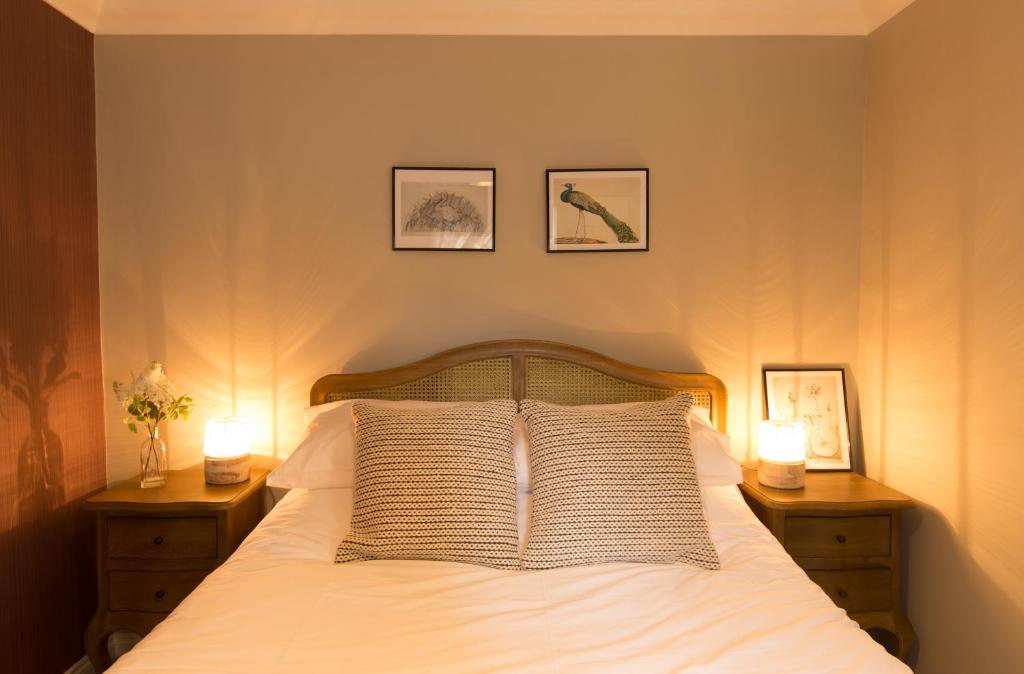1 dormitorio con 1 cama con 2 mesitas de noche y 2 lámparas en Willoughby Apartment, en Bath