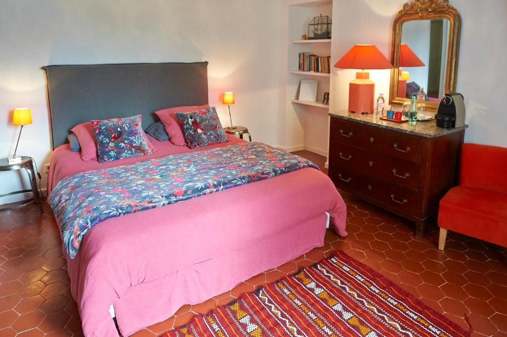 a bedroom with a bed and a dresser and a mirror at La Grande Maison De Nans in Nans-les-Pins