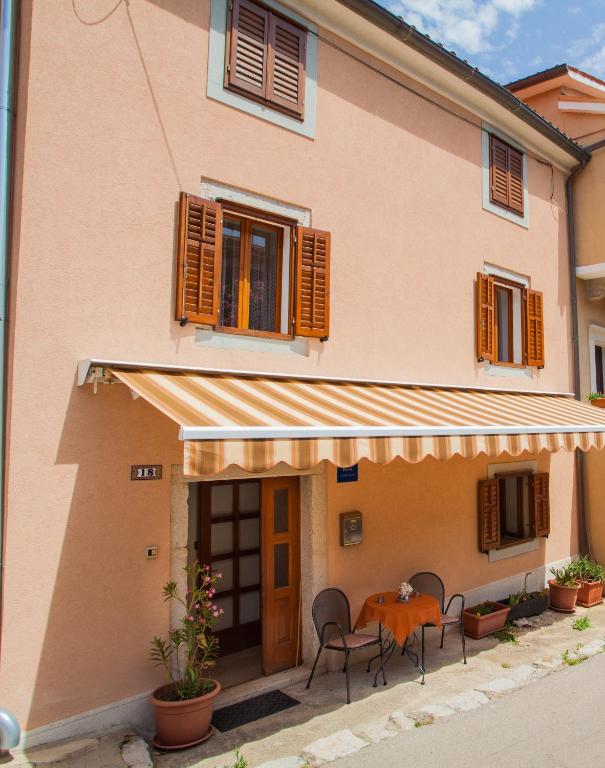 a house with a table and chairs in front of it at Apartment Rialto with private parking in Cres