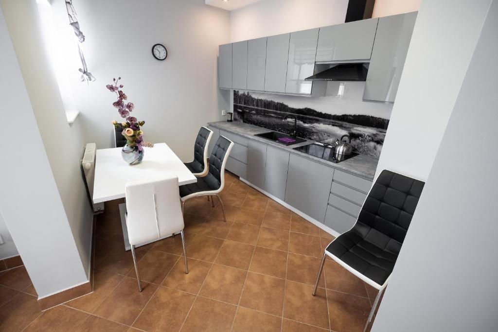 a kitchen with a white table and chairs at Apartament Augustów in Augustów