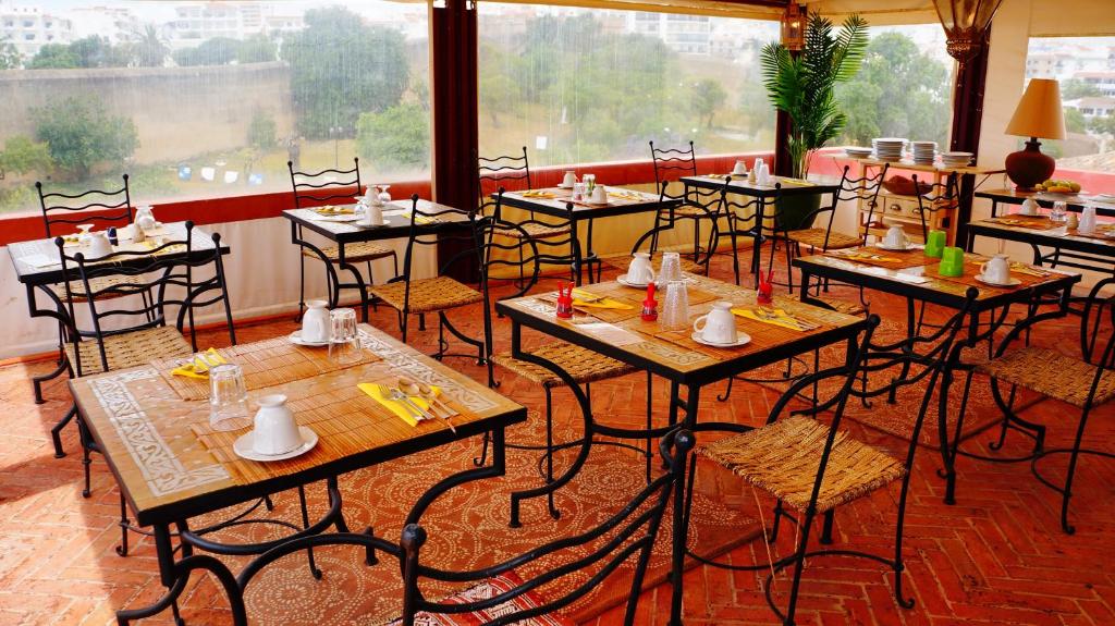 a restaurant with tables and chairs and a large window at Casa da Moura in Lagos