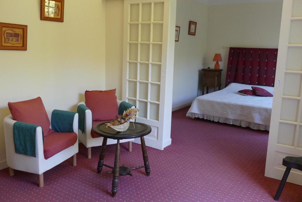 - une chambre avec deux chaises, une table et un lit dans l'établissement Chambres d'Hôtes Haitz Ondo, à Hasparren