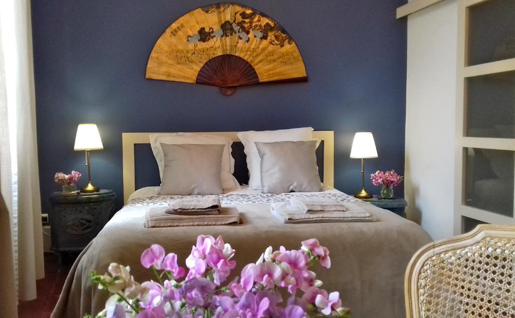 ein Schlafzimmer mit einem Bett mit lila Blumen in der Unterkunft Ombre Rose in Le Fousseret