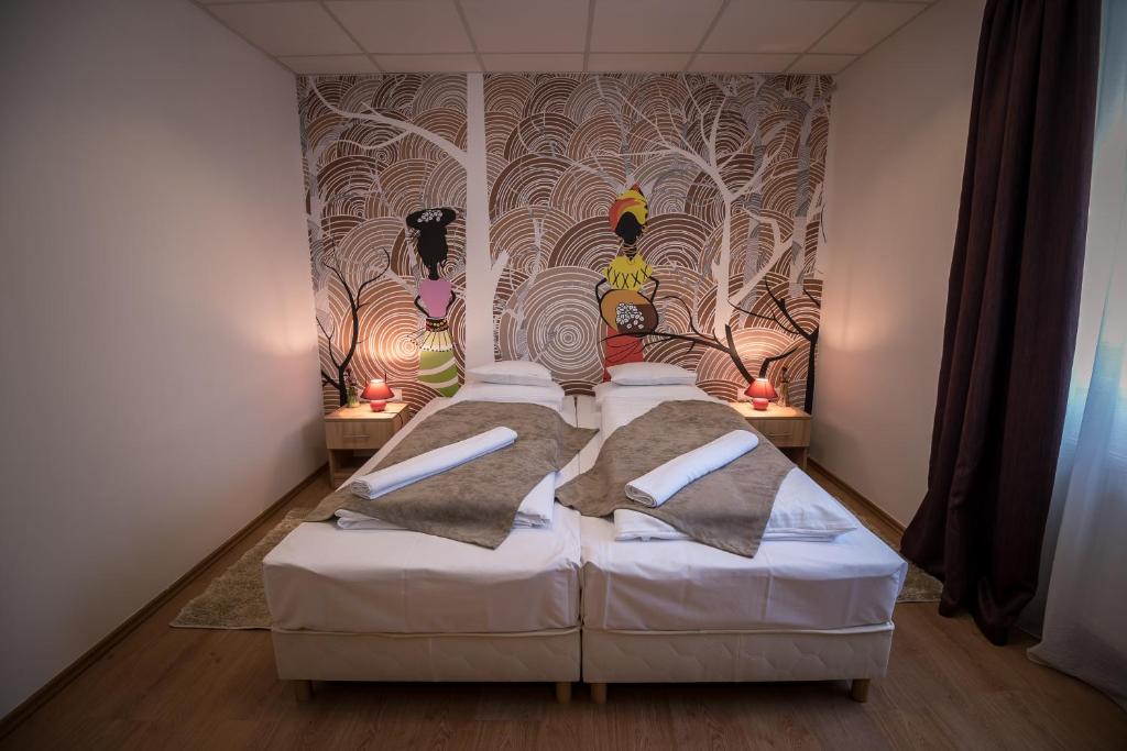 a bedroom with a bed with a wall mural at Mokka Apartman Szeged in Szeged