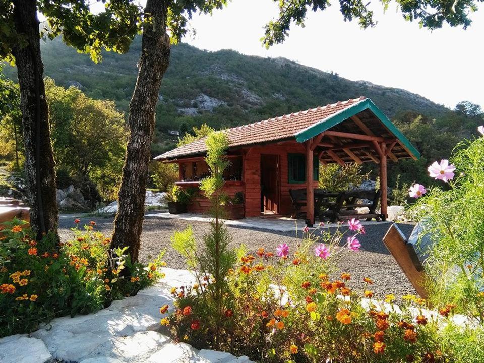 uma pequena cabana de madeira com um ramo de flores em Camp Oaza,Lipa em Cetinje