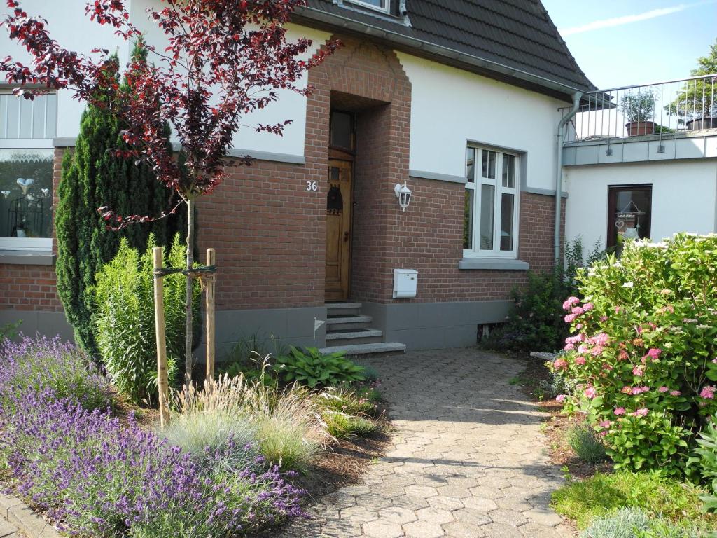 a brick house with flowers in front of it at Ferienwohnung Spatzennest in Wesel