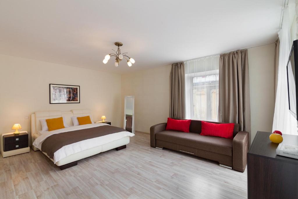 1 dormitorio con 1 cama y 1 sofá en Lights Apartments with two bedrooms in the center of city, en Leópolis