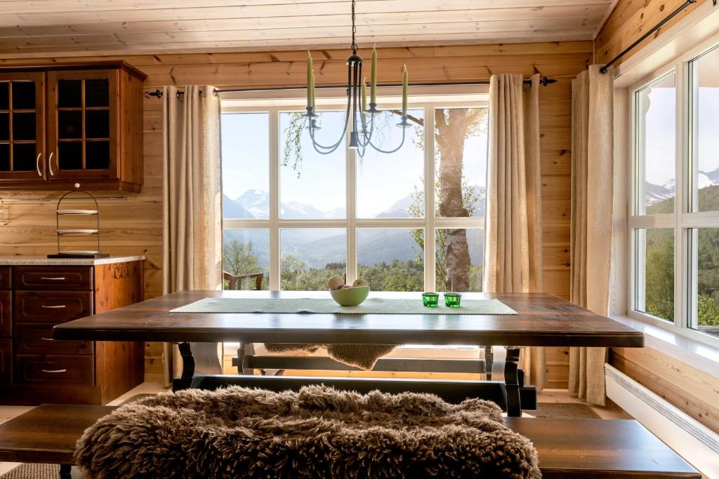 ein Esszimmer mit einem Tisch und einem großen Fenster in der Unterkunft Valley View in Stranda