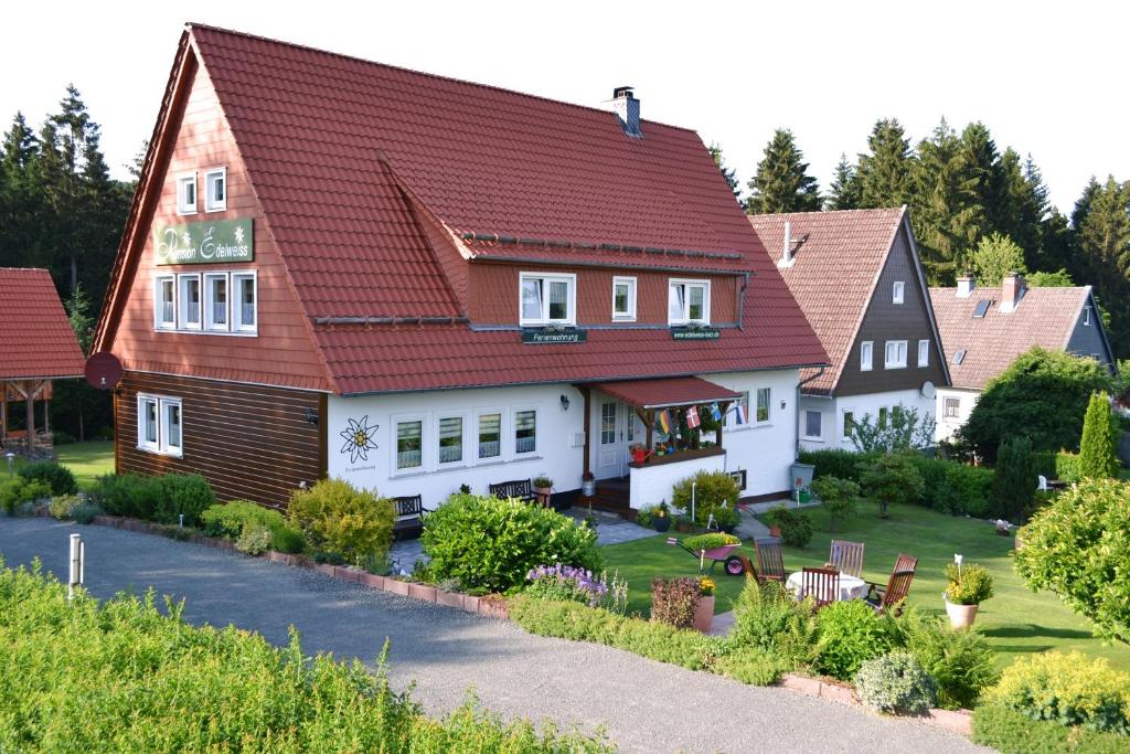 una casa con techo rojo en Ferienwohnungen Edelweiss, en Schulenberg im Oberharz