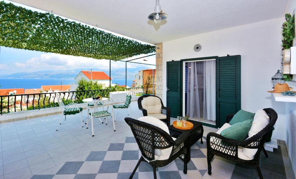 a patio with a table and chairs and a view of the ocean at Apartment Pepica with sea view in Postira