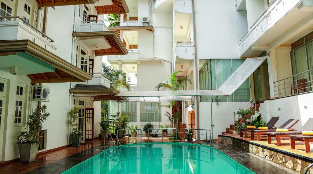 an apartment with a swimming pool in a building at Oak Ray Serene Garden Hotel in Kandy