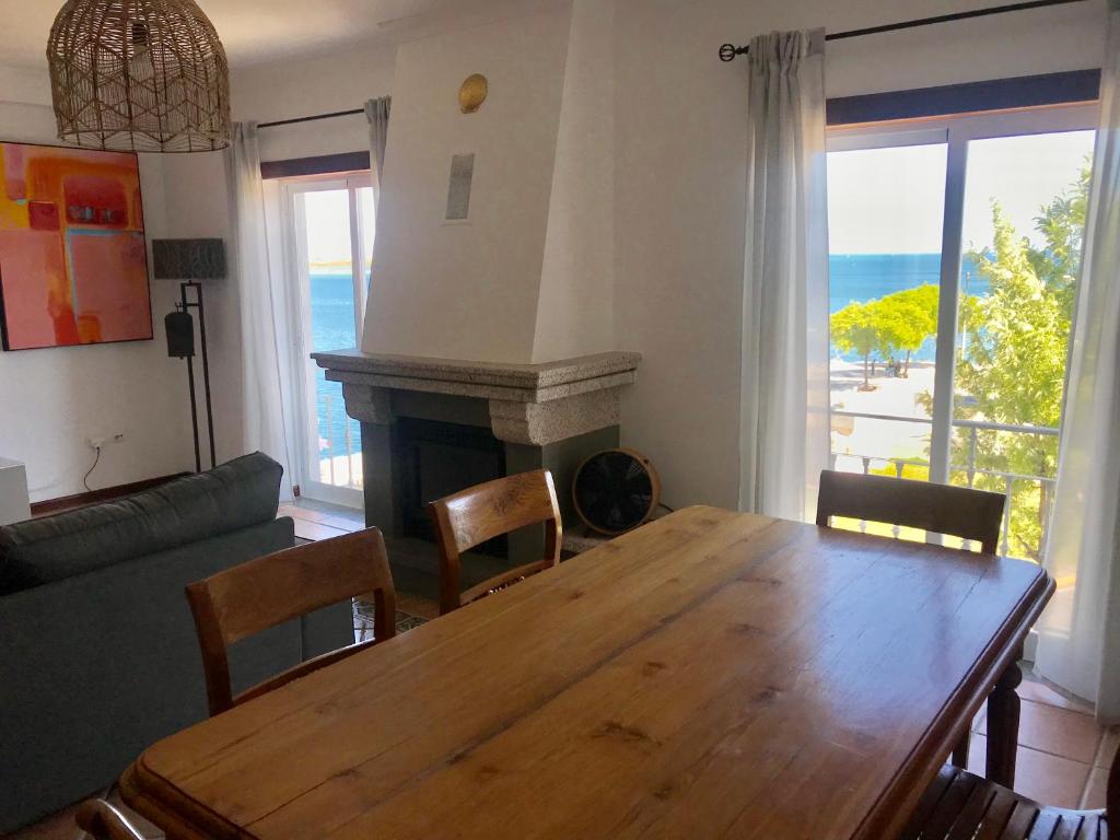 sala de estar con mesa de madera y chimenea en Seaside doors en Vila Real de Santo António