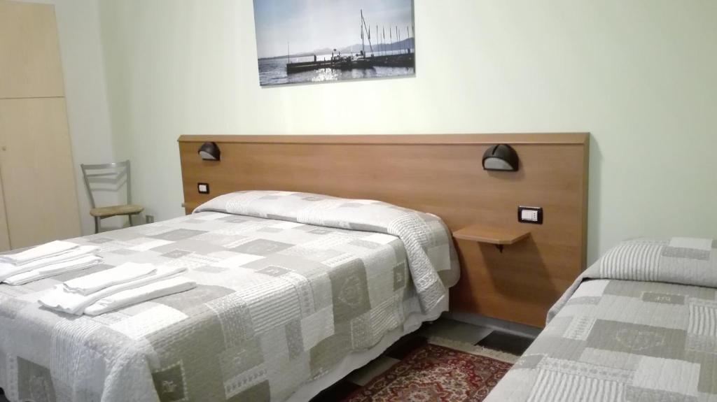 1 dormitorio con 1 cama con cabecero de madera en Appartamenti Calicante, en Bardolino