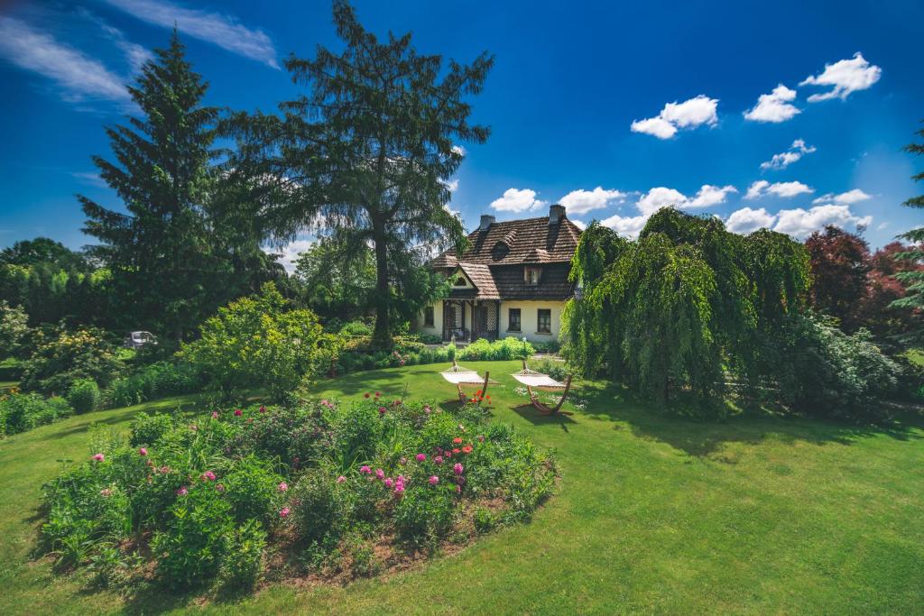 a house with a garden with flowers and trees at Folwark Walencja in Kazimierz Dolny