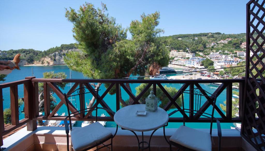 einen Balkon mit einem Tisch und Stühlen sowie Blick auf das Wasser in der Unterkunft Liadromia Hotel in Patitiri