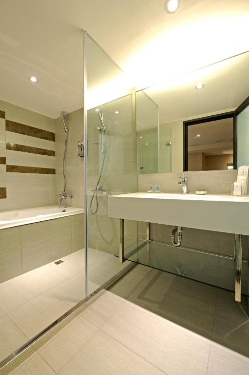 a bathroom with a tub and a sink and a shower at International Citizen Hotel in Kaohsiung